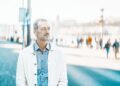 Firmenstrukturen in Ungarn: Norbert Peter aus Hannover hilft 10 Unternehmer mit grauem Bart blickt auf Stadtplatz – Symbolbild für grenzüberschreitende Beratung